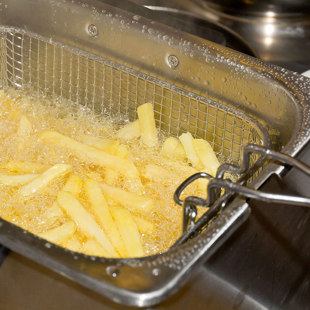 Pommes Frites in einer Fritteuse